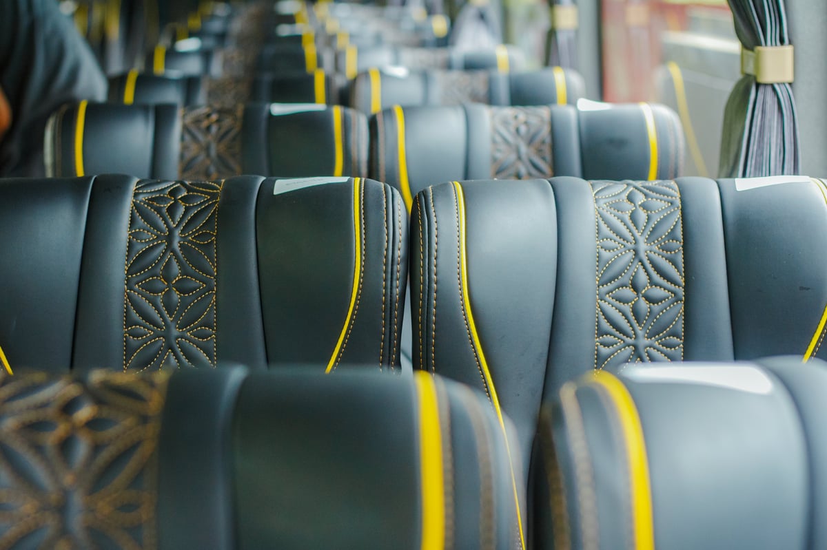 Premium coach seats with black leather and gold piping